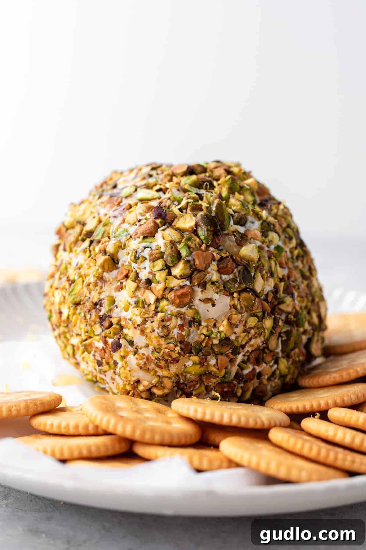 Pistachio and Honey Coated Cheese Ball, a Perfect Party Appetizer Festive cheese ball covered in pistachios, drizzled with honey, and garnished with lemon zest.