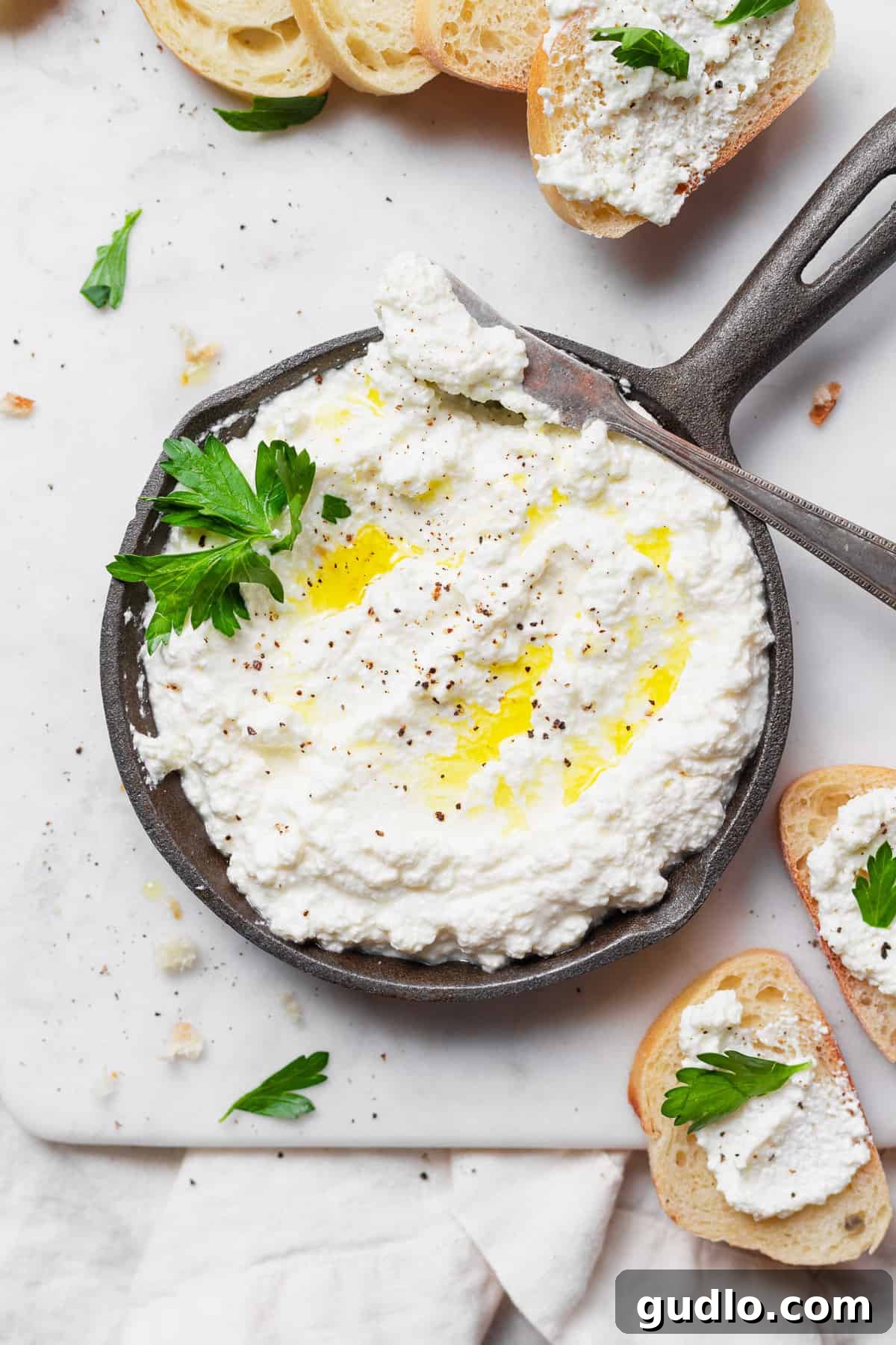 Crafting Fresh Ricotta at Home 2 Freshly made homemade ricotta cheese in a white bowl, garnished with herbs.