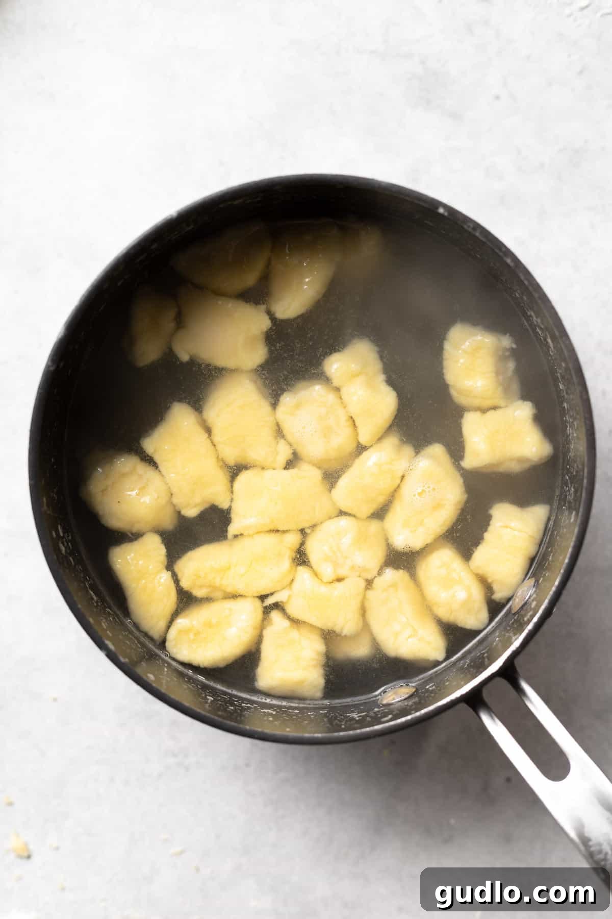 Boiling Ricotta Gnocchi to Perfection Ricotta gnocchi gently bubbling and floating in a large pot of salted boiling water, indicating they are perfectly cooked.