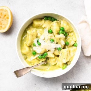 Pillowy Homemade Ricotta Gnocchi 3 A beautifully plated dish of tender ricotta gnocchi served with a vibrant sweet pea butter sauce, garnished with fresh mint, ready to be enjoyed.