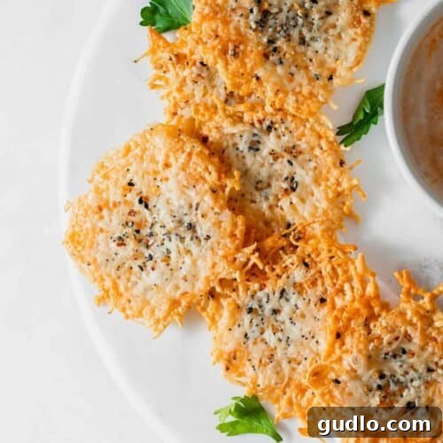 Parmesan cheese crisps on a plate, showcasing their perfect golden-brown color and crunchy texture.