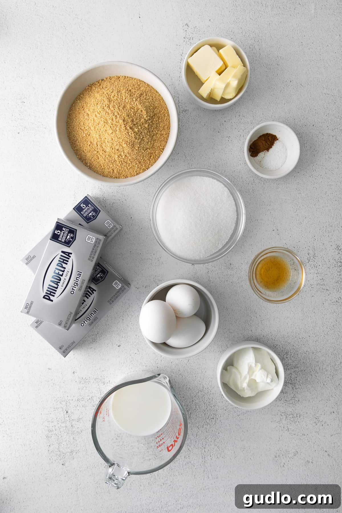 Essential Ingredients for Your Perfect Instant Pot Cheesecake Various Instant Pot cheesecake ingredients meticulously arranged in small bowls, showcasing freshness and quality.