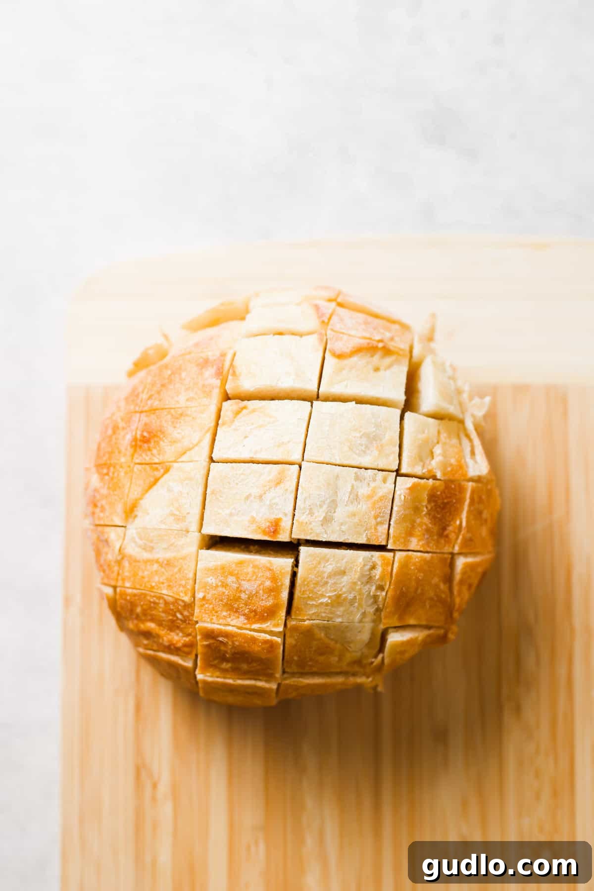 Sourdough bread loaf sliced diagonally into diamond shapes, ready for stuffing