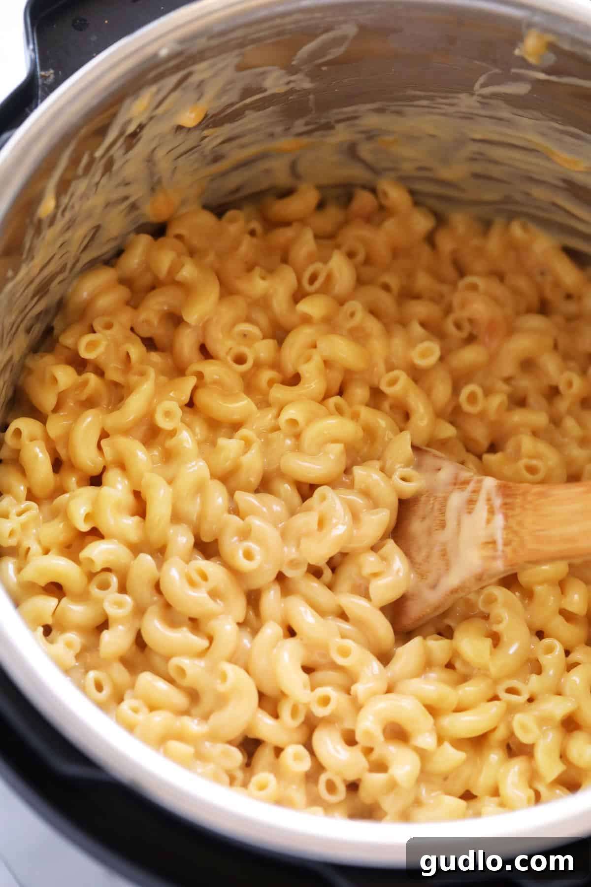 A large pot of steaming, creamy Instant Pot Mac and Cheese, with golden-brown melted cheese visible, ready to be served.