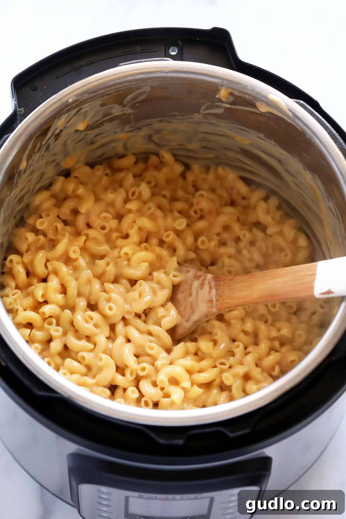 Close-up of gloriously creamy Instant Pot Mac and Cheese simmering in the Instant Pot, with its rich, golden sauce perfectly coating the macaroni, ready to be served.