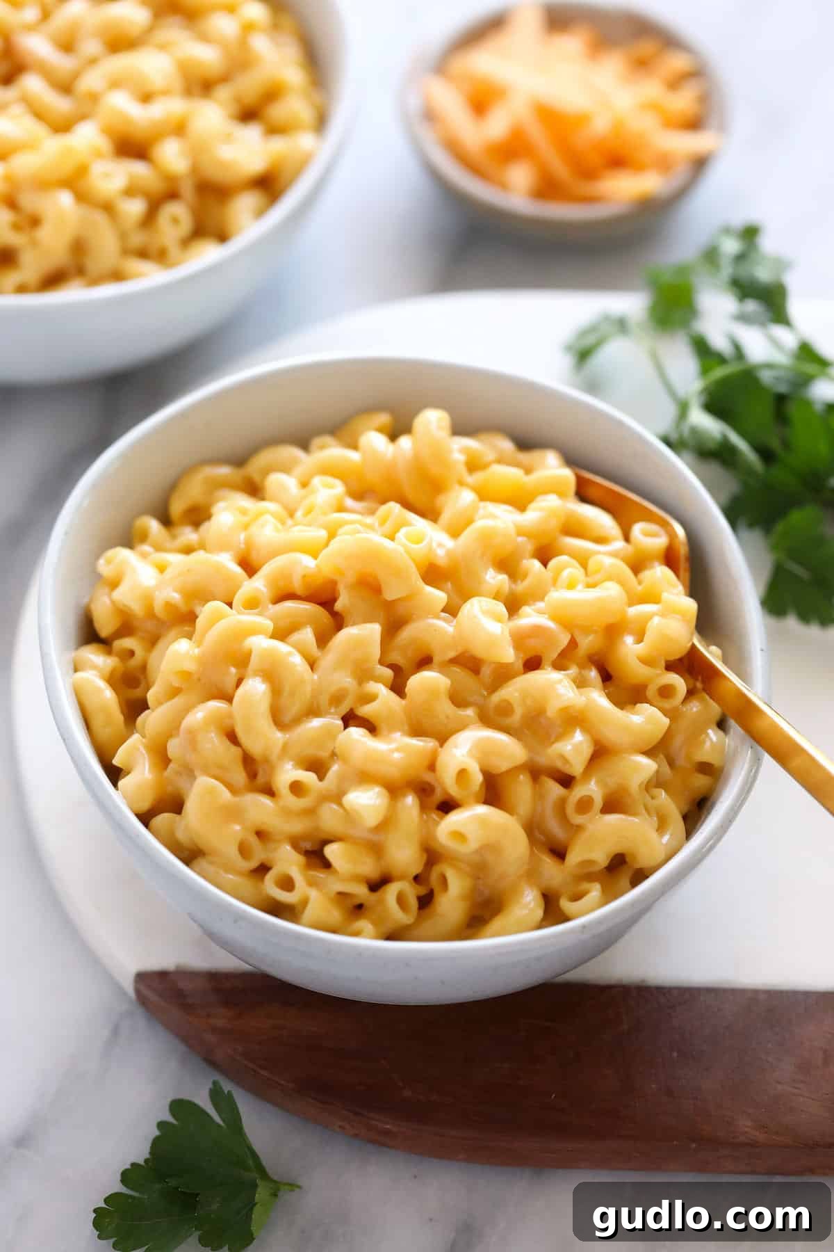 A beautifully presented bowl of hot, creamy Instant Pot Mac and Cheese, garnished with a sprinkle of fresh green herbs, ready to be enjoyed.