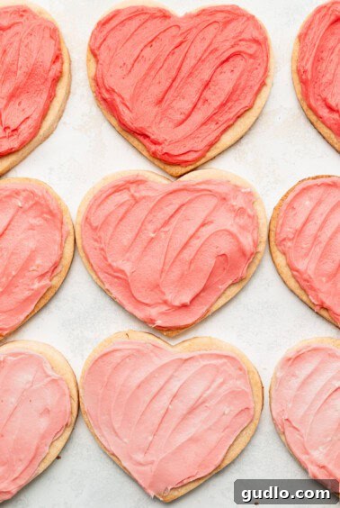 Freshly baked cream cheese heart cookies cooling on a wire rack, awaiting their frosting.