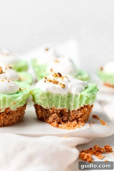 Pistachio pie cups topped with whipped cream and crushed pistachios.