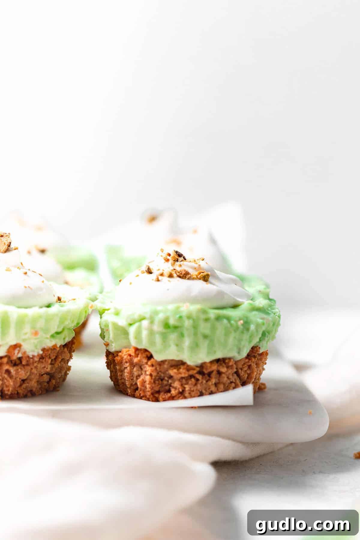 Pistachio pie cups with a dollop of whip and sprinkle of pistachios on top. Finished pistachio pie cups with a dollop of whipped cream and a sprinkle of chopped pistachios on top, ready to be served.