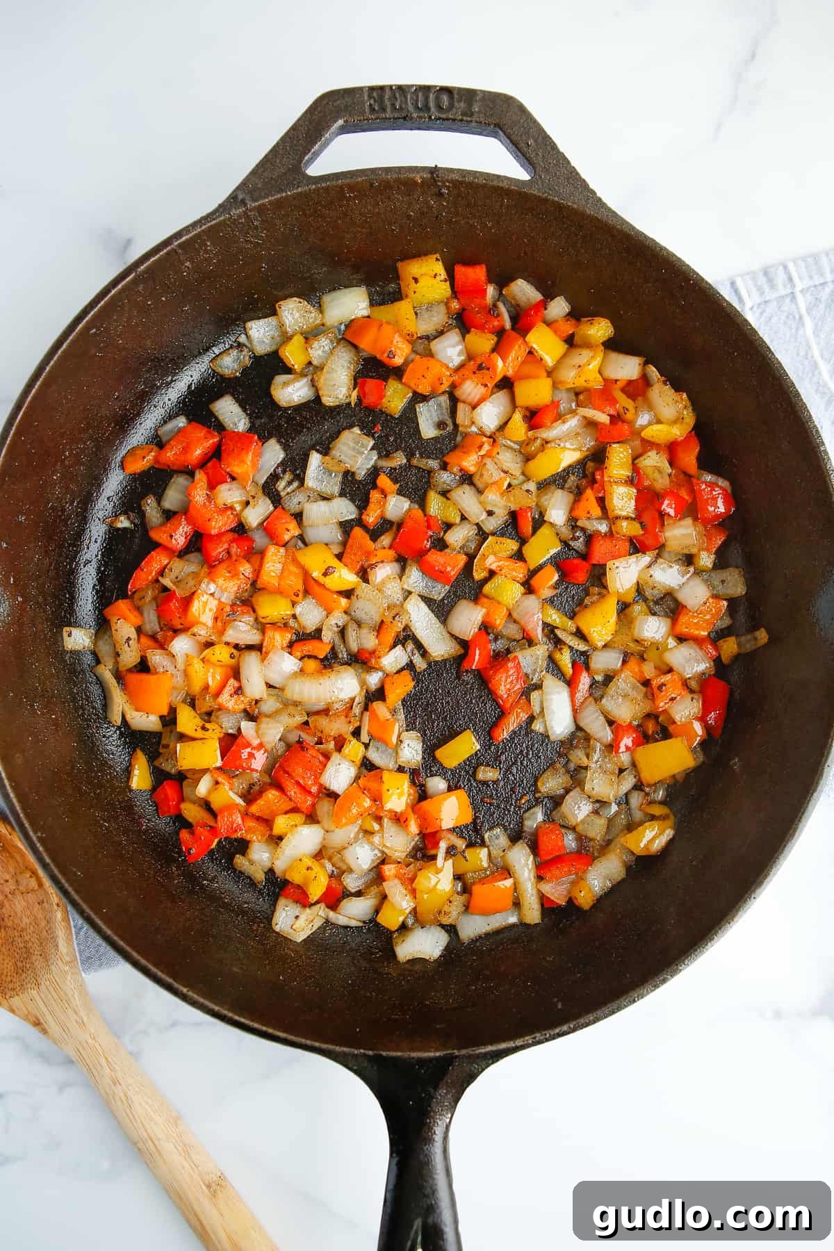 Sizzling Skillet Breakfast Potatoes 5 Diced bell peppers and onions sautéing in a cast iron pan with sausage drippings.