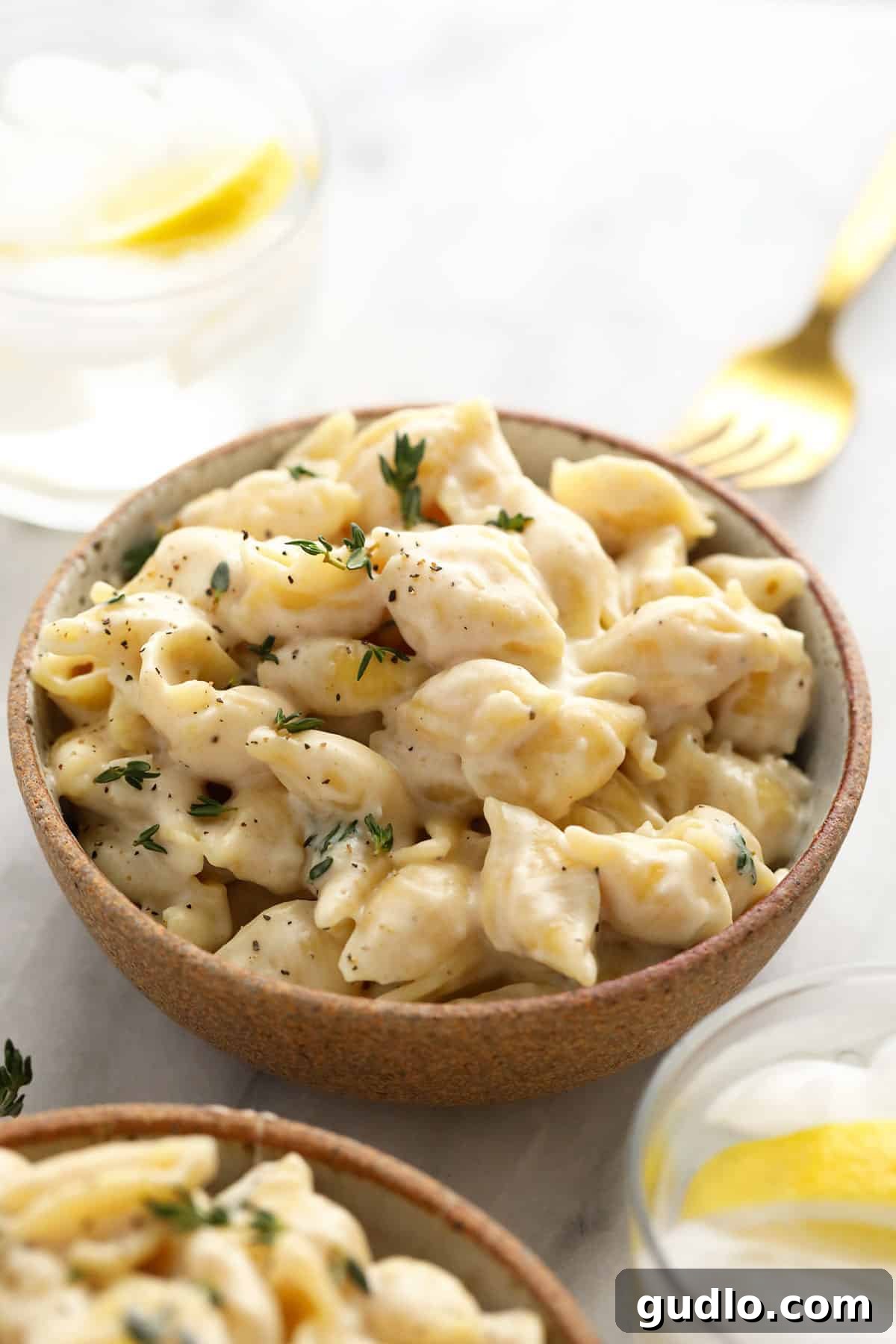 A bowl of creamy Brie Mac and Cheese garnished with fresh chopped parsley.