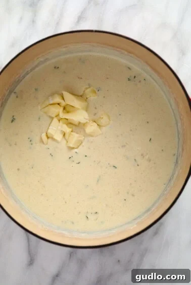 Melted brie cheese sauce in a pan with garlic.