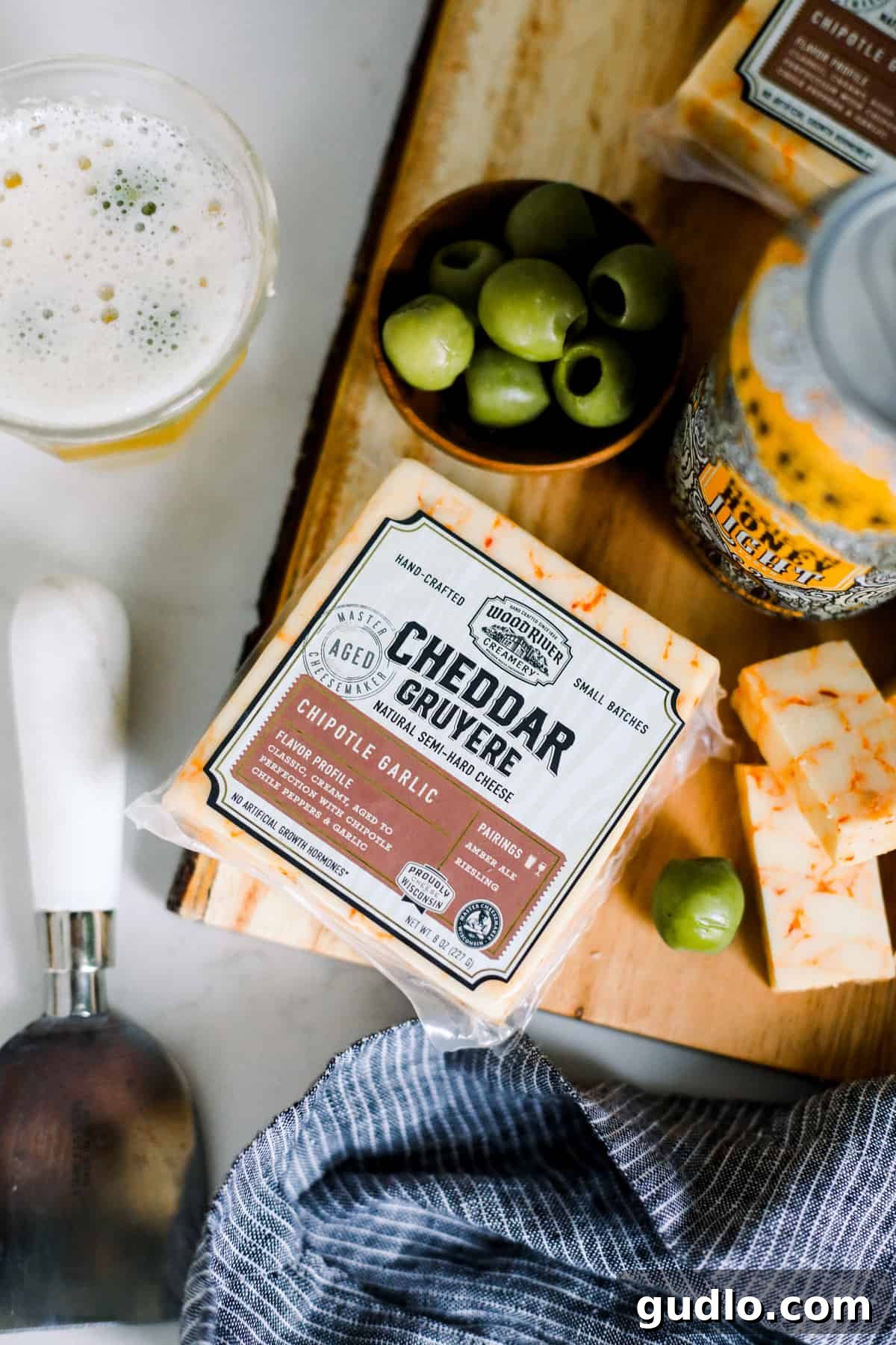Spicy Cheese & Refreshing Lager: A Bold Flavor Duo Wood River Creamery Creamy Chipotle Garlic cheese with green olives, perfectly paired with Indeed Brewing Mexican Honey Light Lager.