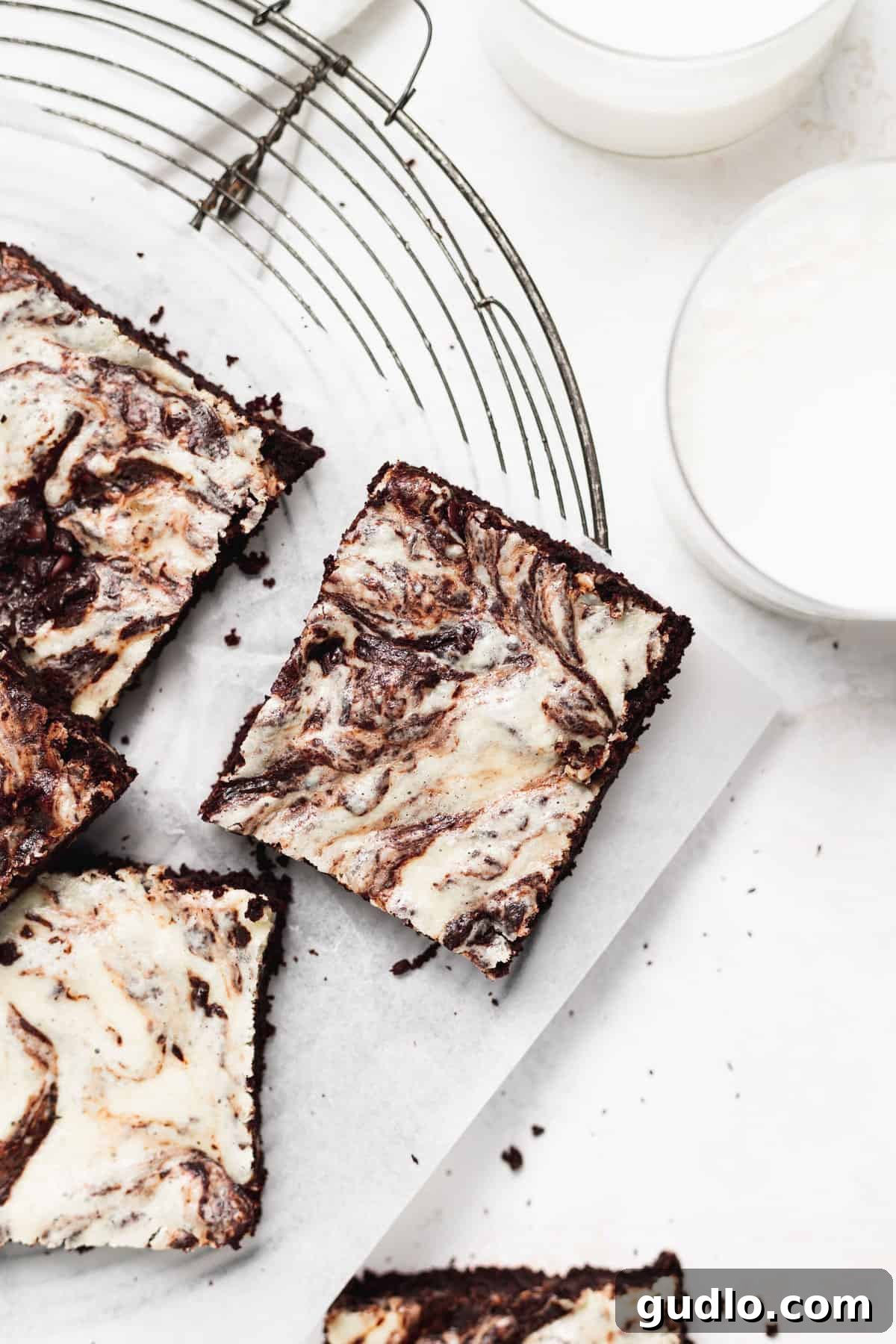 Decadent Cream Cheese Swirl Brownies 2 Cream cheese brownies on a cooling rack, showcasing their beautiful swirled top.