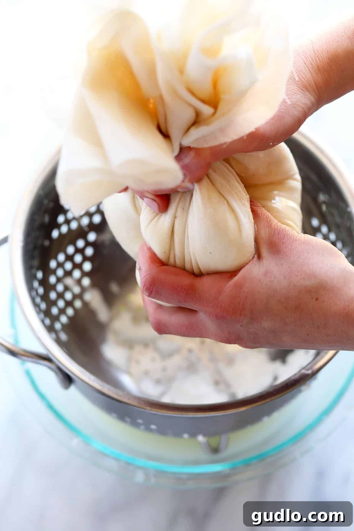 The Art of Making Queso Fresco at Home 8 Squeezing excess whey from queso fresco curds held in cheesecloth.