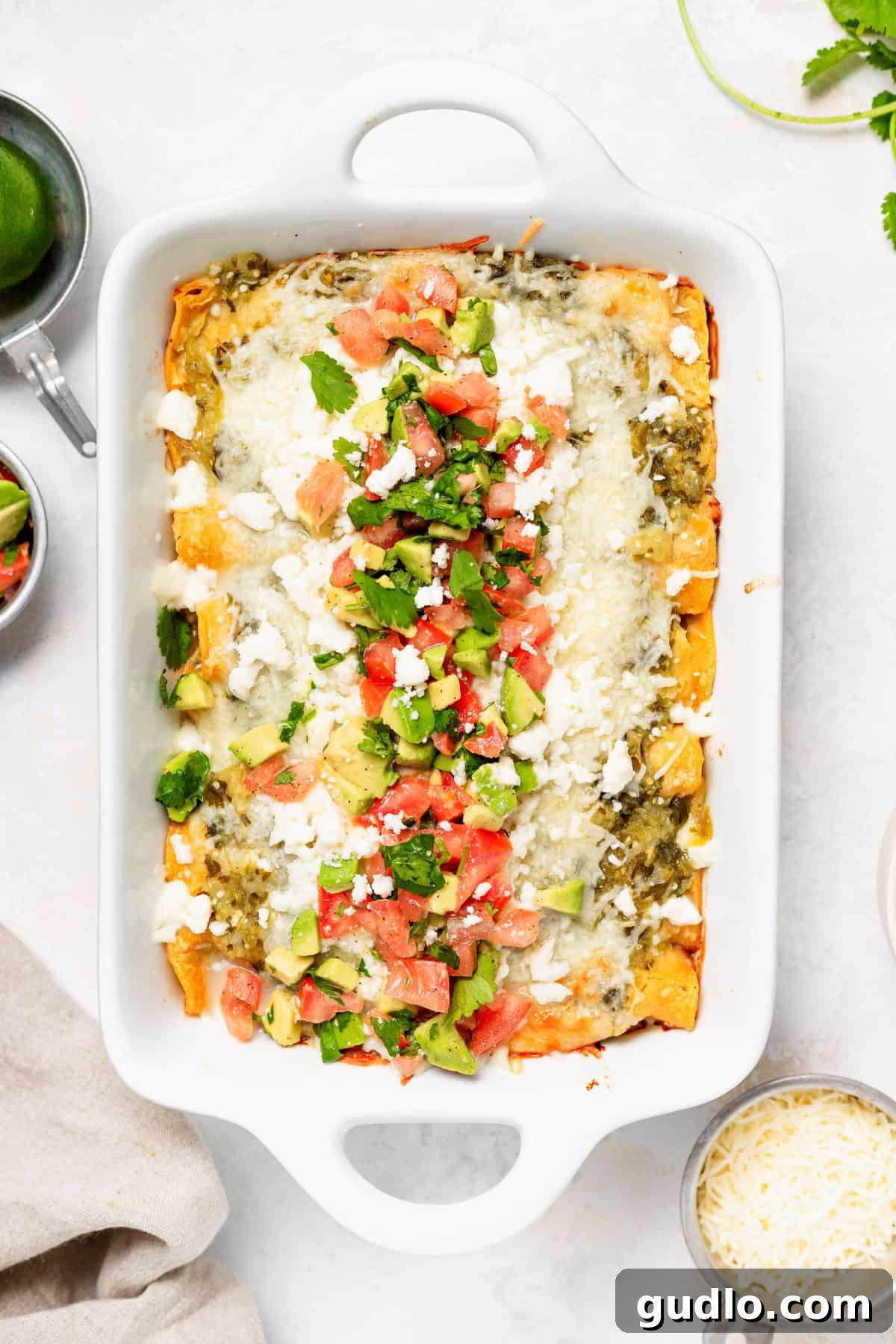 Comforting Homestyle Chicken Enchiladas 2 A golden-brown casserole dish brimming with perfectly baked chicken enchiladas, topped with a luscious salsa verde and melted Monterey Jack cheese, ready to be served.