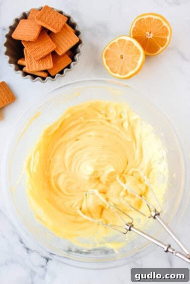 a bowl of whipped cream with oranges and crackers.