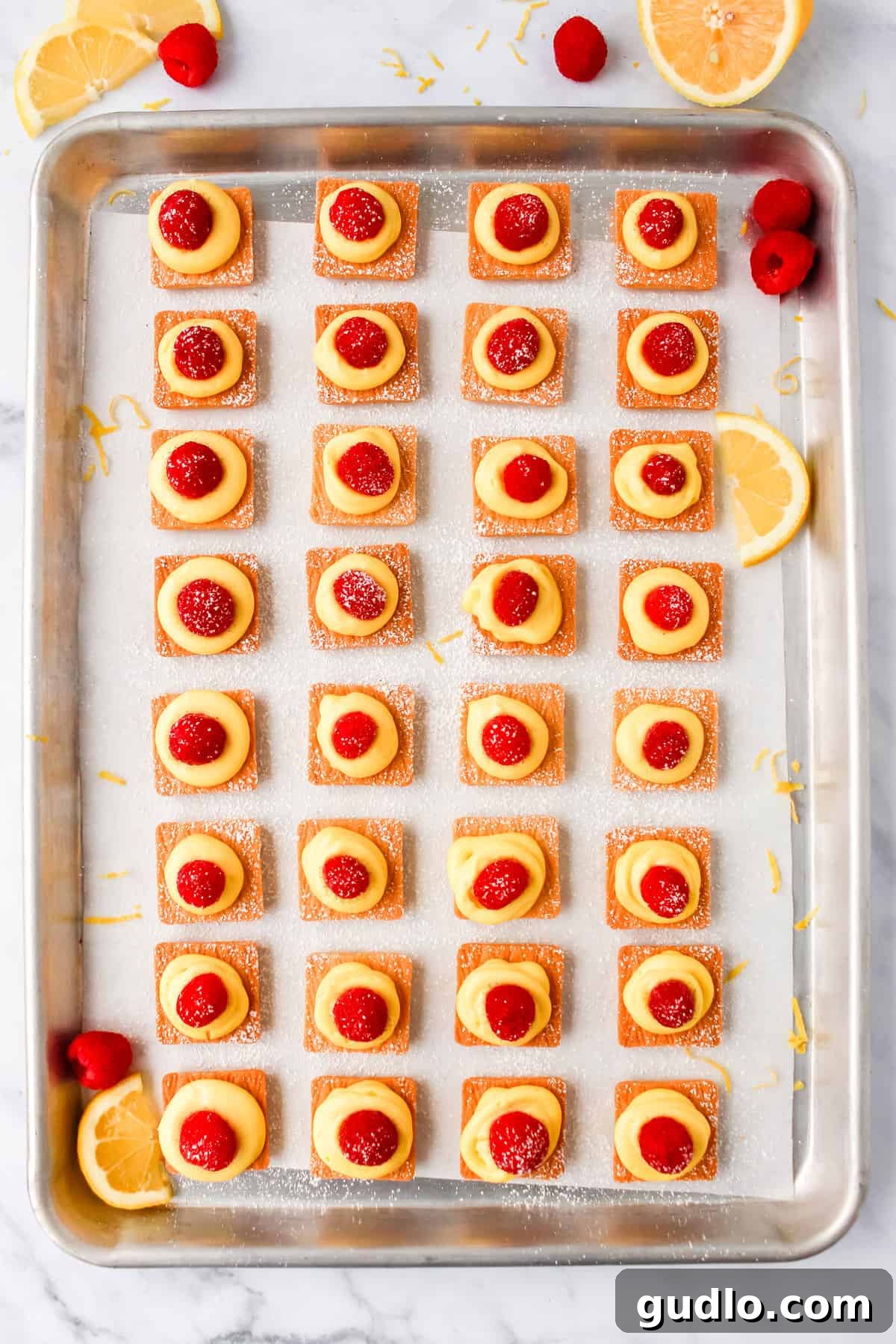mini lemon cheesecakes on a baking sheet, ready to chill