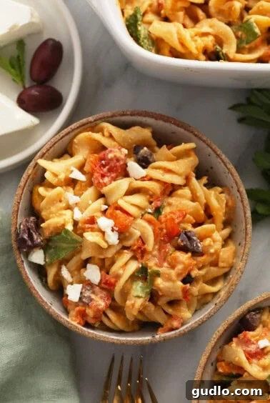 Roasted Feta Tomato Pasta Perfection 6 A bowl of baked feta pasta, ready to be served, garnished with fresh herbs and olives.