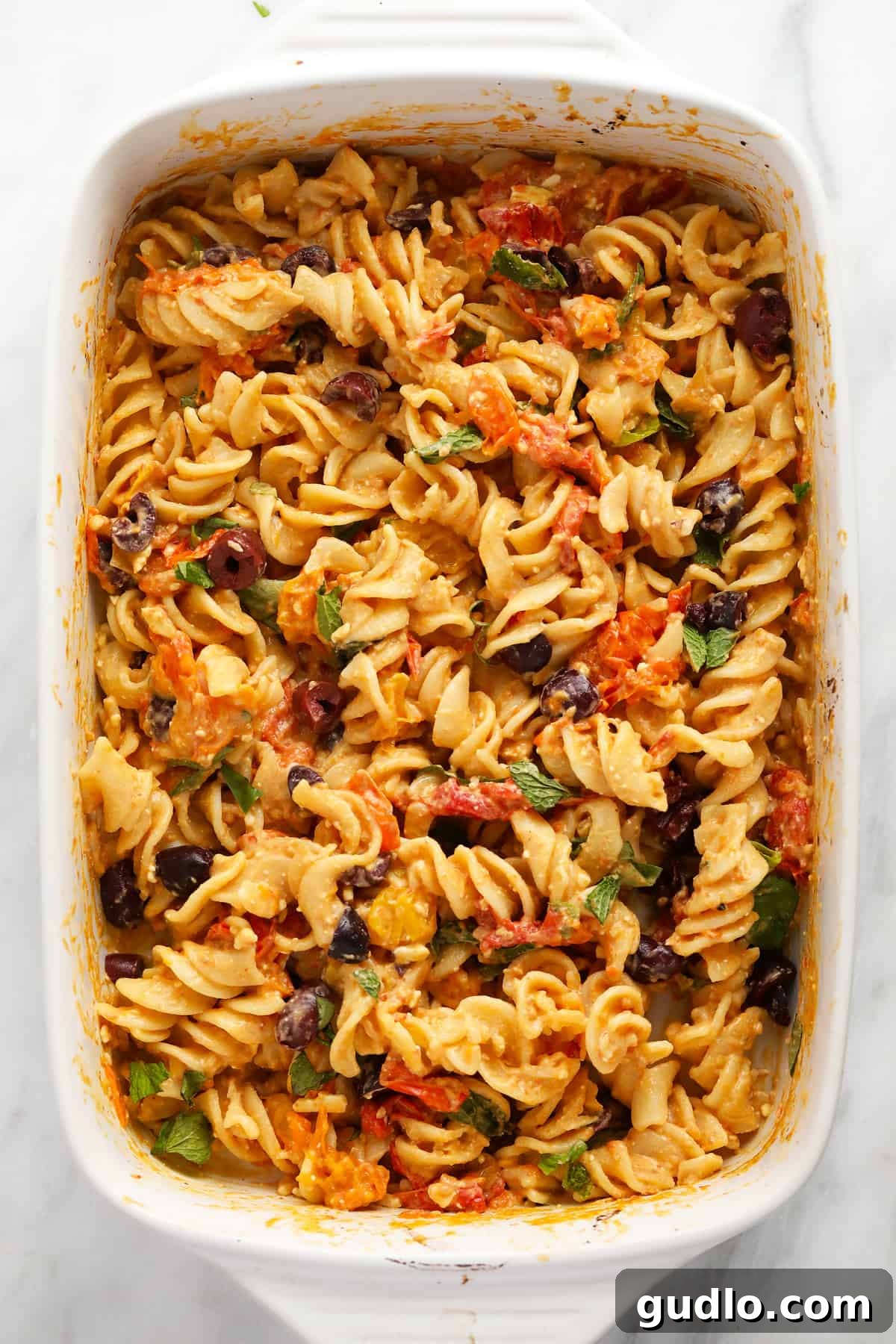 Baked Feta Pasta, a simple and flavorful meal. A visually stunning bowl of baked feta pasta, garnished with fresh basil leaves and a sprinkle of black pepper, ready to be enjoyed.