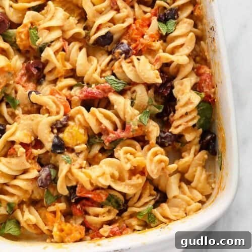 Baked feta pasta in a rustic casserole dish with fresh basil garnish.