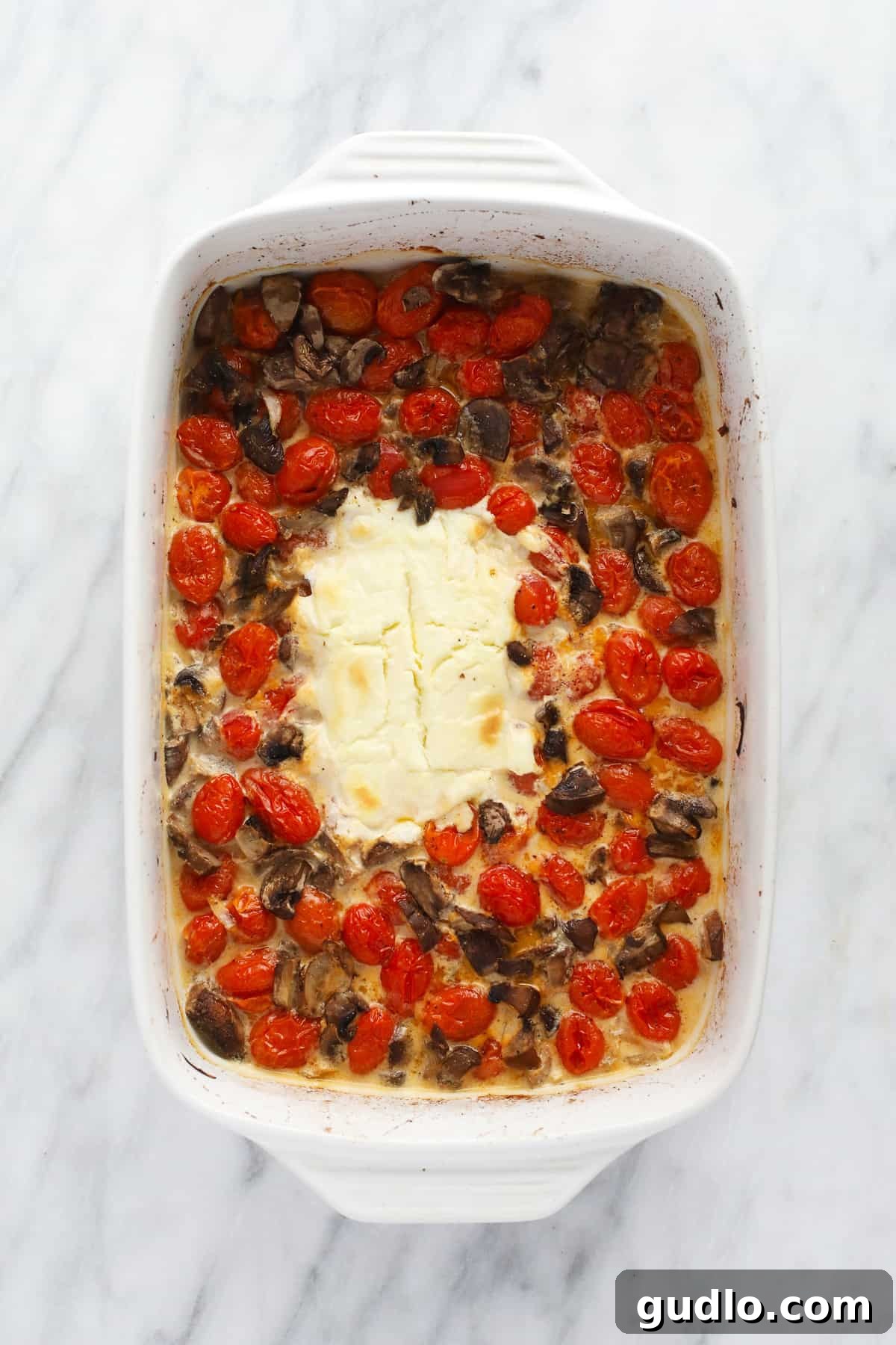 Creamy Pasta Sauce After Baking The baked cream cheese pasta sauce after roasting for 40 minutes, showcasing softened tomatoes, tender mushrooms, and a golden-brown cream cheese block, ready to be mixed.