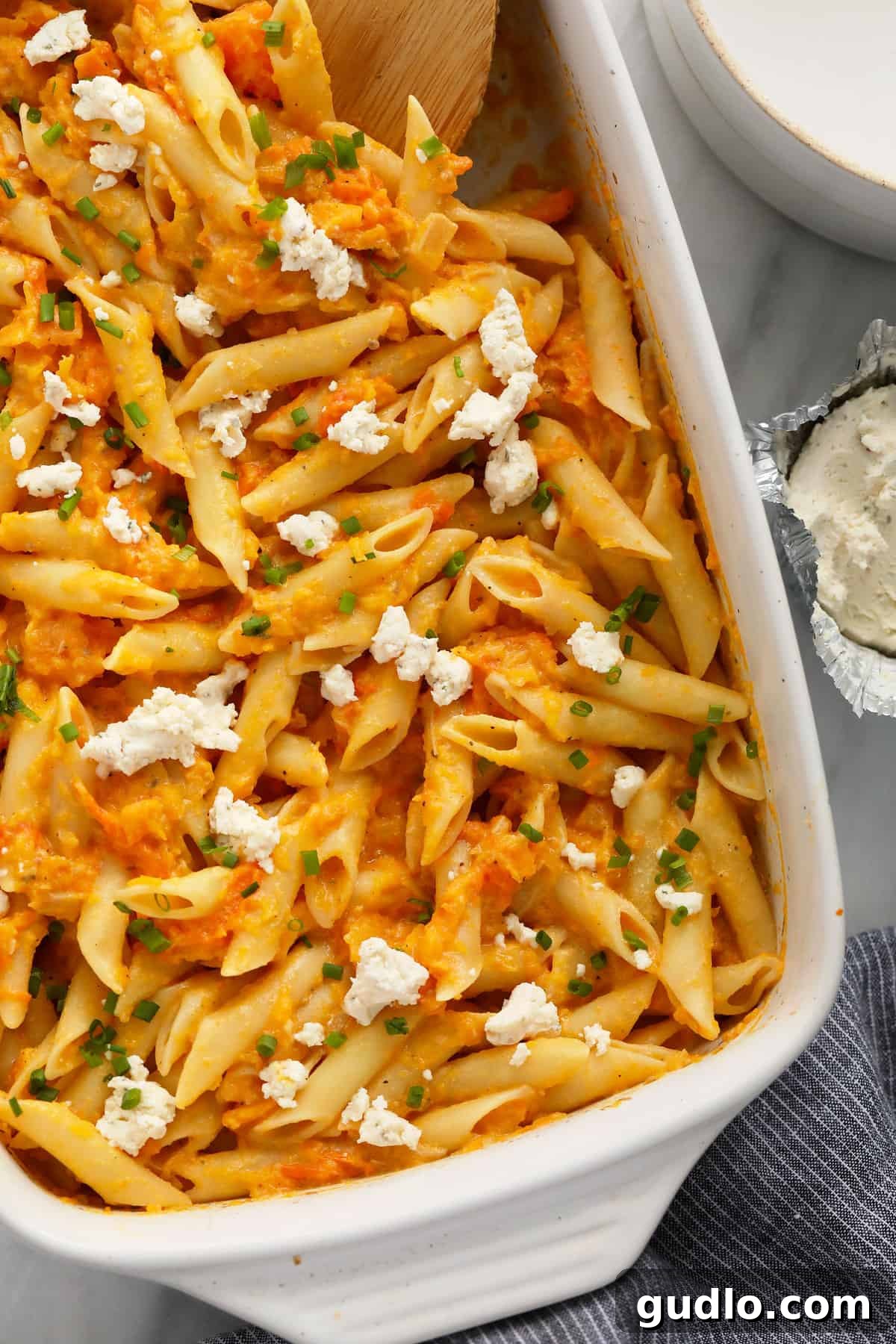 Butternut Squash Pasta Ready to Enjoy Plated creamy baked butternut squash pasta in a casserole dish, garnished with chives