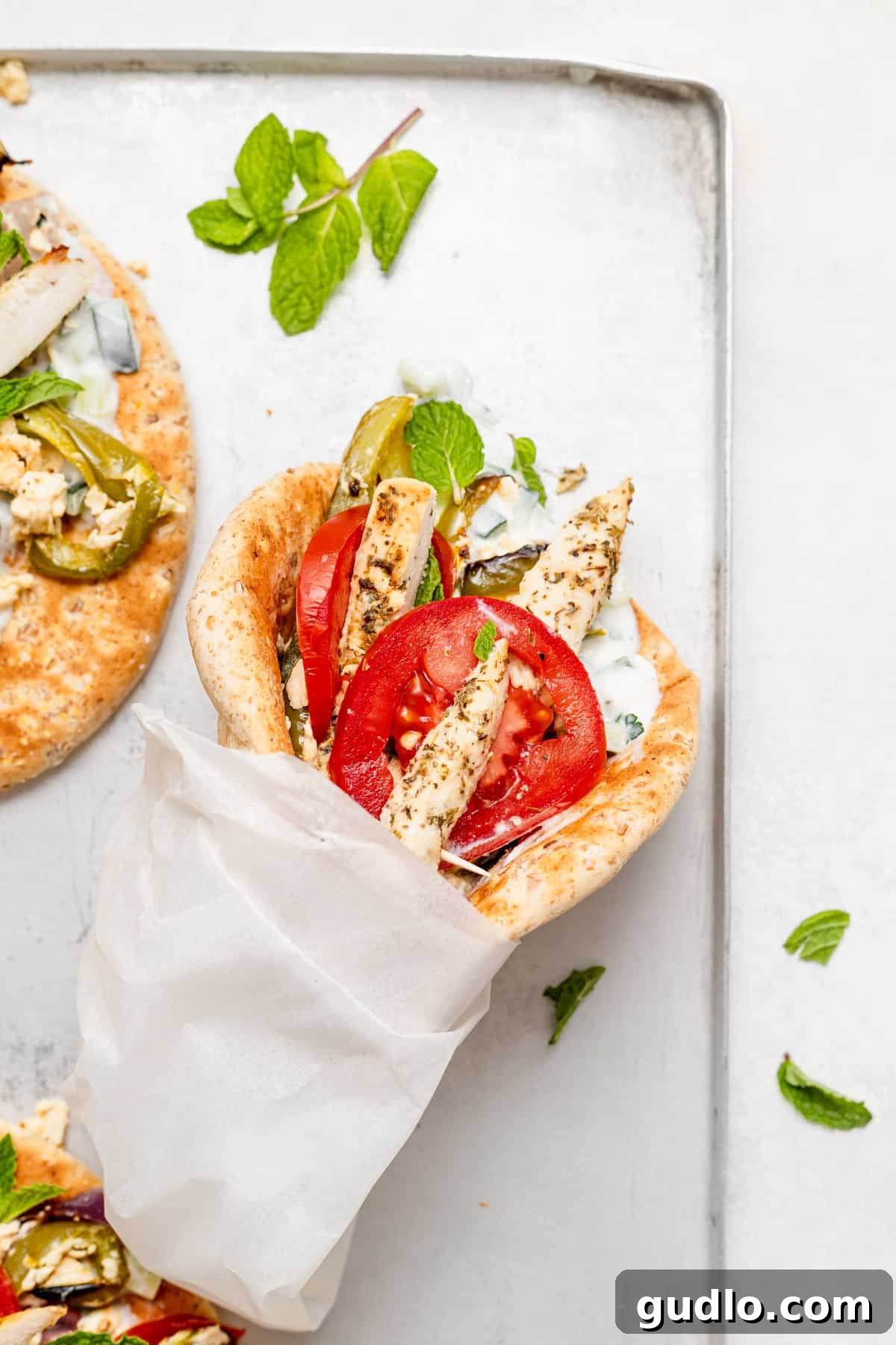Sheet Pan Mediterranean Chicken Gyros 2 Flavorful sheet pan chicken gyros with creamy baked feta and a Greek yogurt sauce, ready for serving.