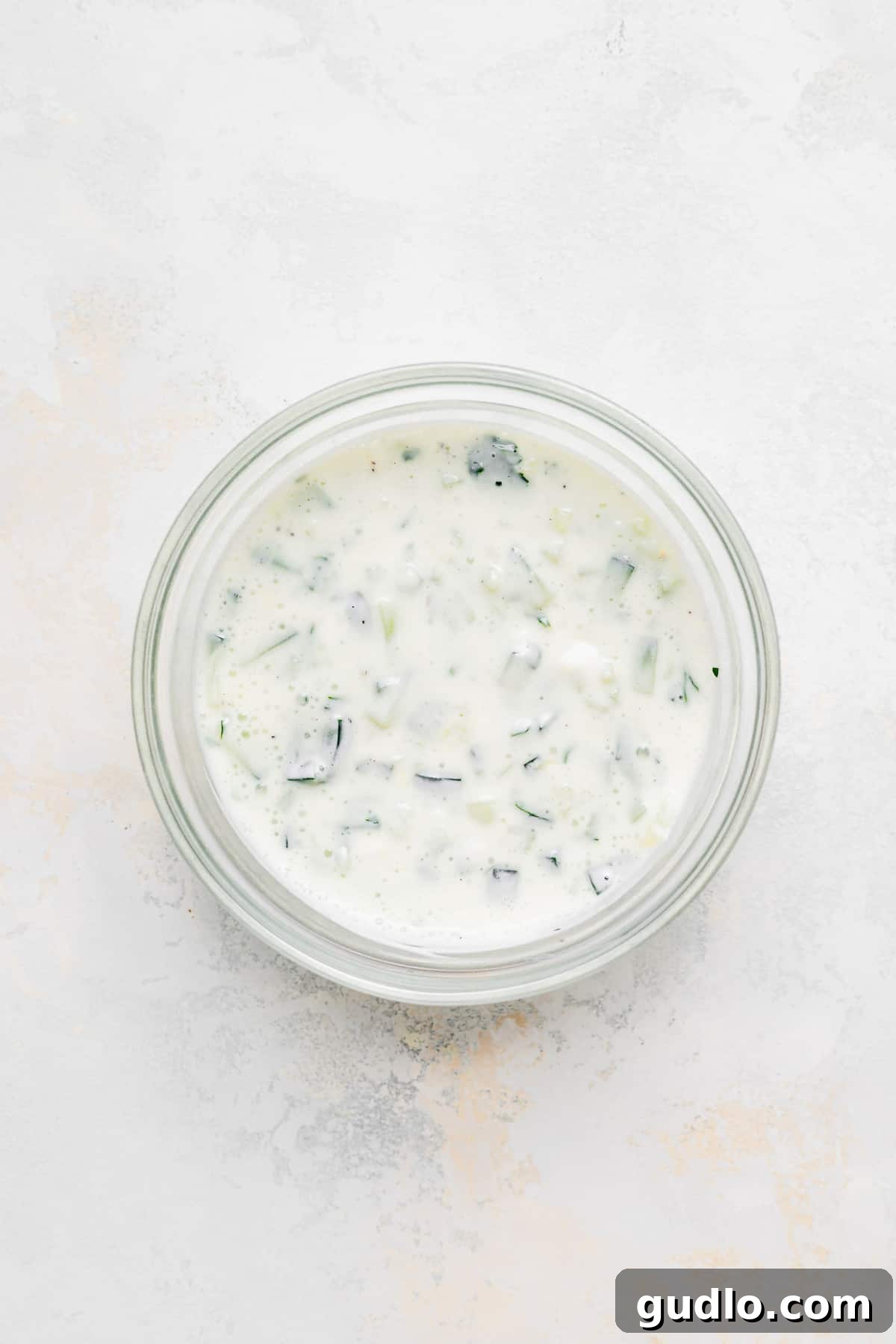 Sheet Pan Mediterranean Chicken Gyros 5 A bowl of freshly prepared, creamy tzatziki sauce, garnished with fresh herbs.