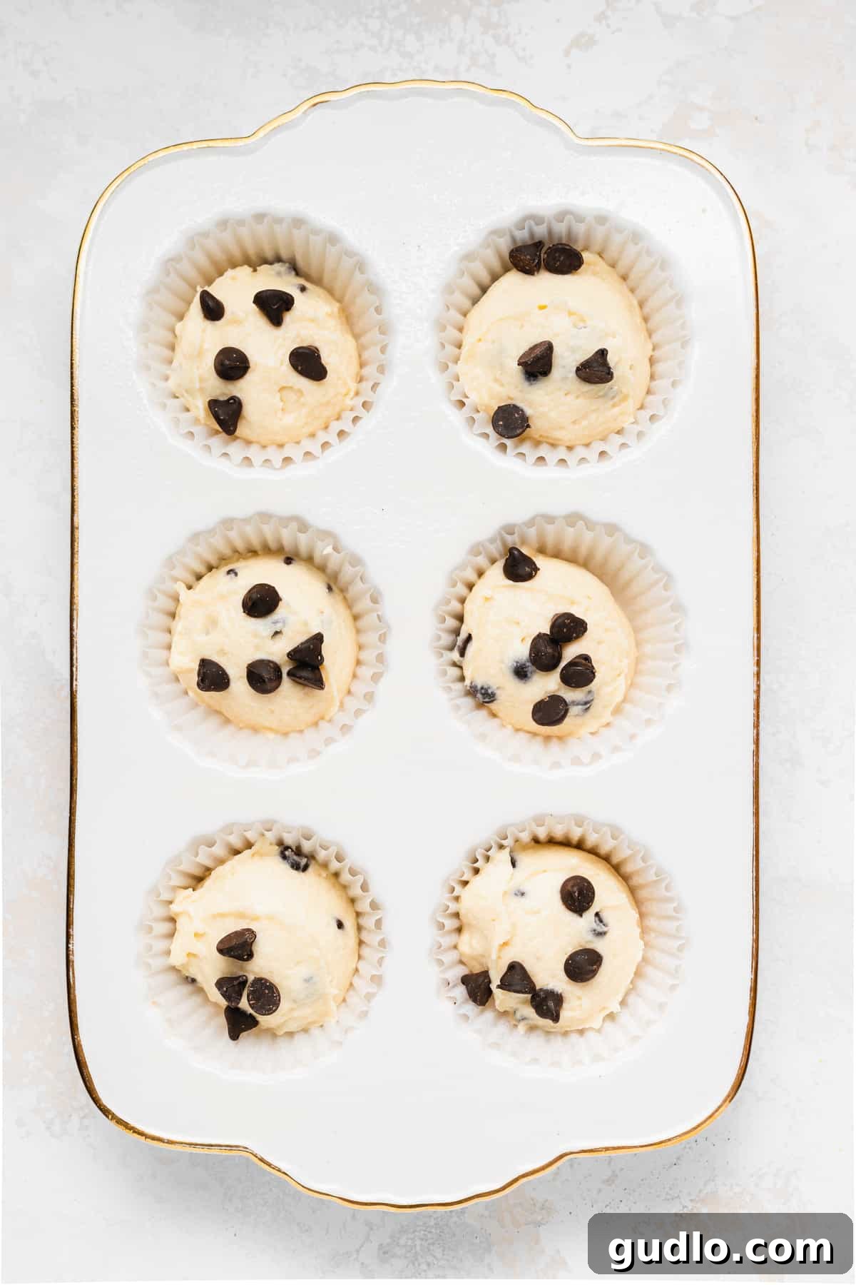 Muffins Ready for Baking Unbaked chocolate chip ricotta muffins perfectly portioned in a muffin tin, ready for the oven to transform them into golden treats.