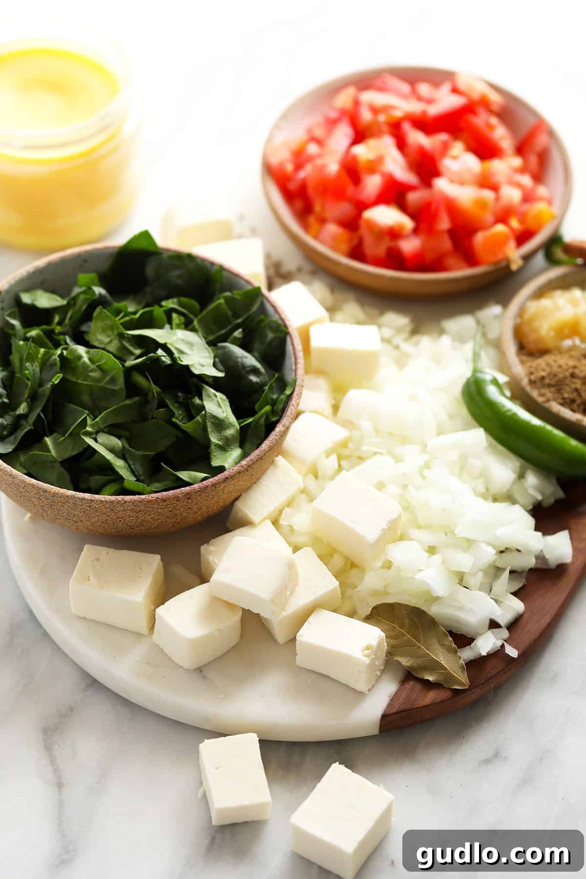 Emerald Spinach and Cottage Cheese Delight 3 A beautiful arrangement of all the fresh ingredients needed for Palak Paneer laid out on a rustic cutting board, highlighting their vibrant colors.