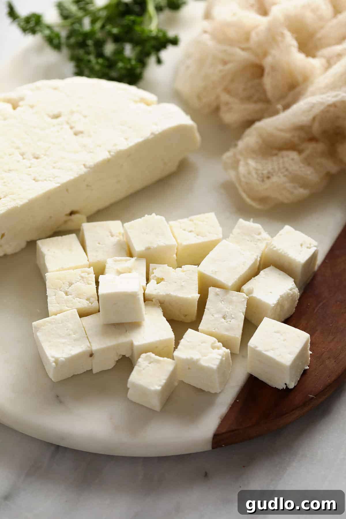Crafting Fresh Paneer at Home 2 Freshly prepared paneer block on a wooden cutting board, ready to be sliced for a delicious Indian curry or dish.