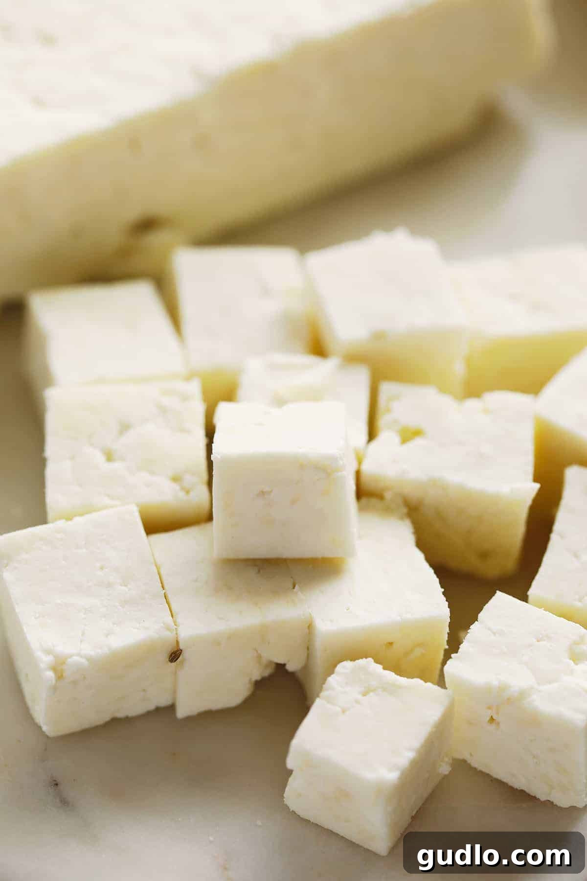 Crafting Fresh Paneer at Home 11 Freshly cut paneer cubes arranged on a cutting board, highlighting its firm yet tender texture.