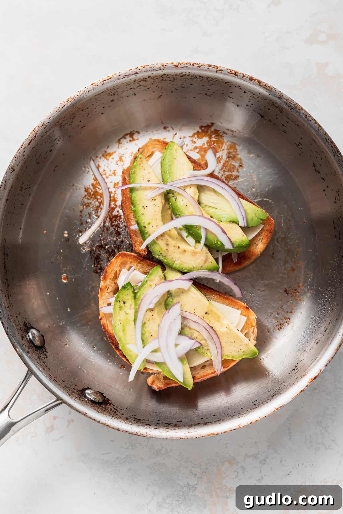 Perfectly Grilled Avocado Cheese Sandwich Avocado grilled cheese cooking in a pan, with the cheese melting beautifully and avocado slices visible.
