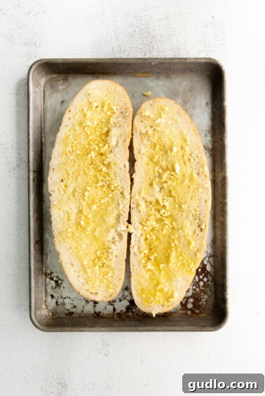 Golden Cheesy Garlic Bliss 12 Sliced Italian loaf with butter and garlic spread on both sides.