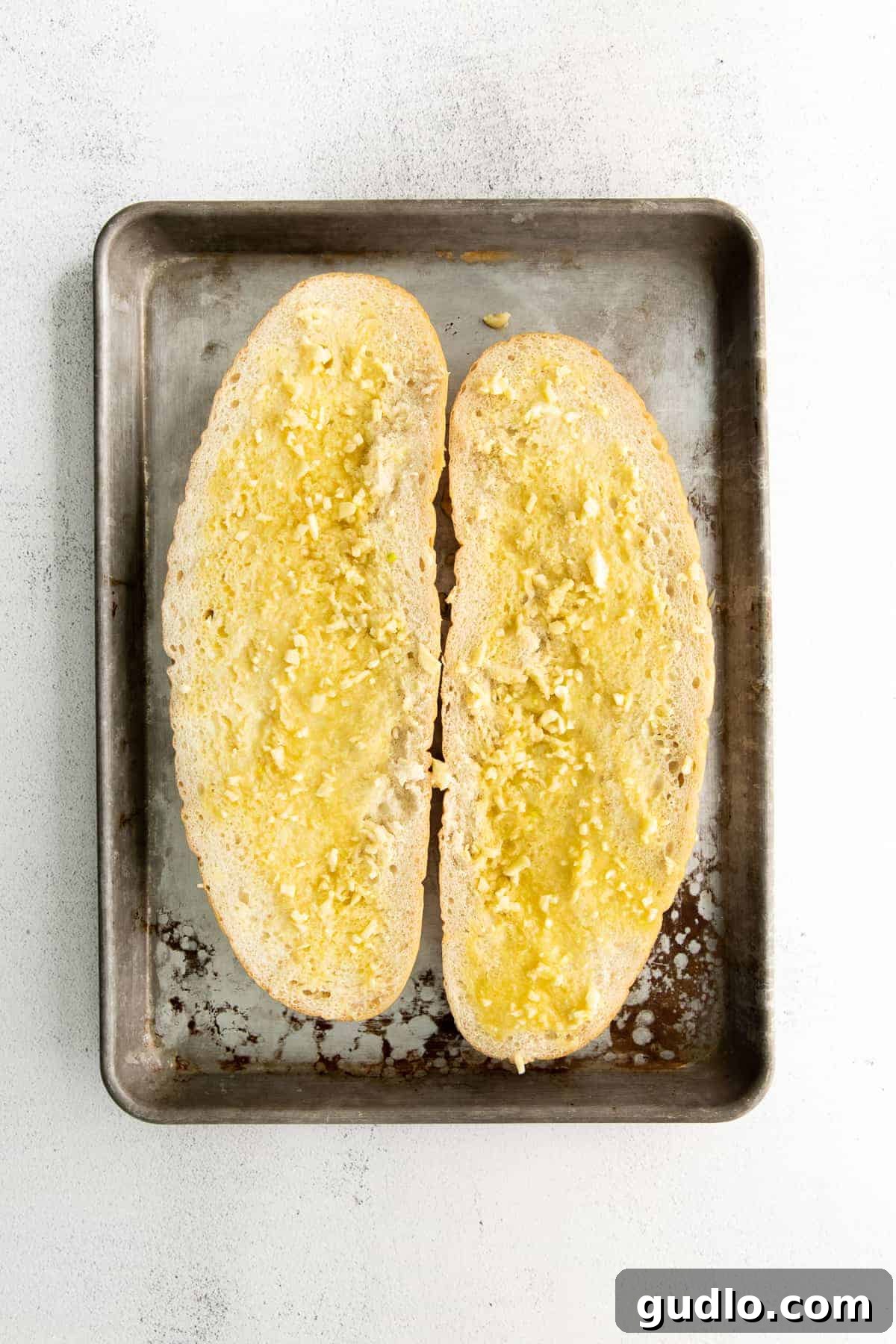 Golden Cheesy Garlic Bliss 5 A sliced loaf of Italian bread slathered with a rich garlic butter mixture.