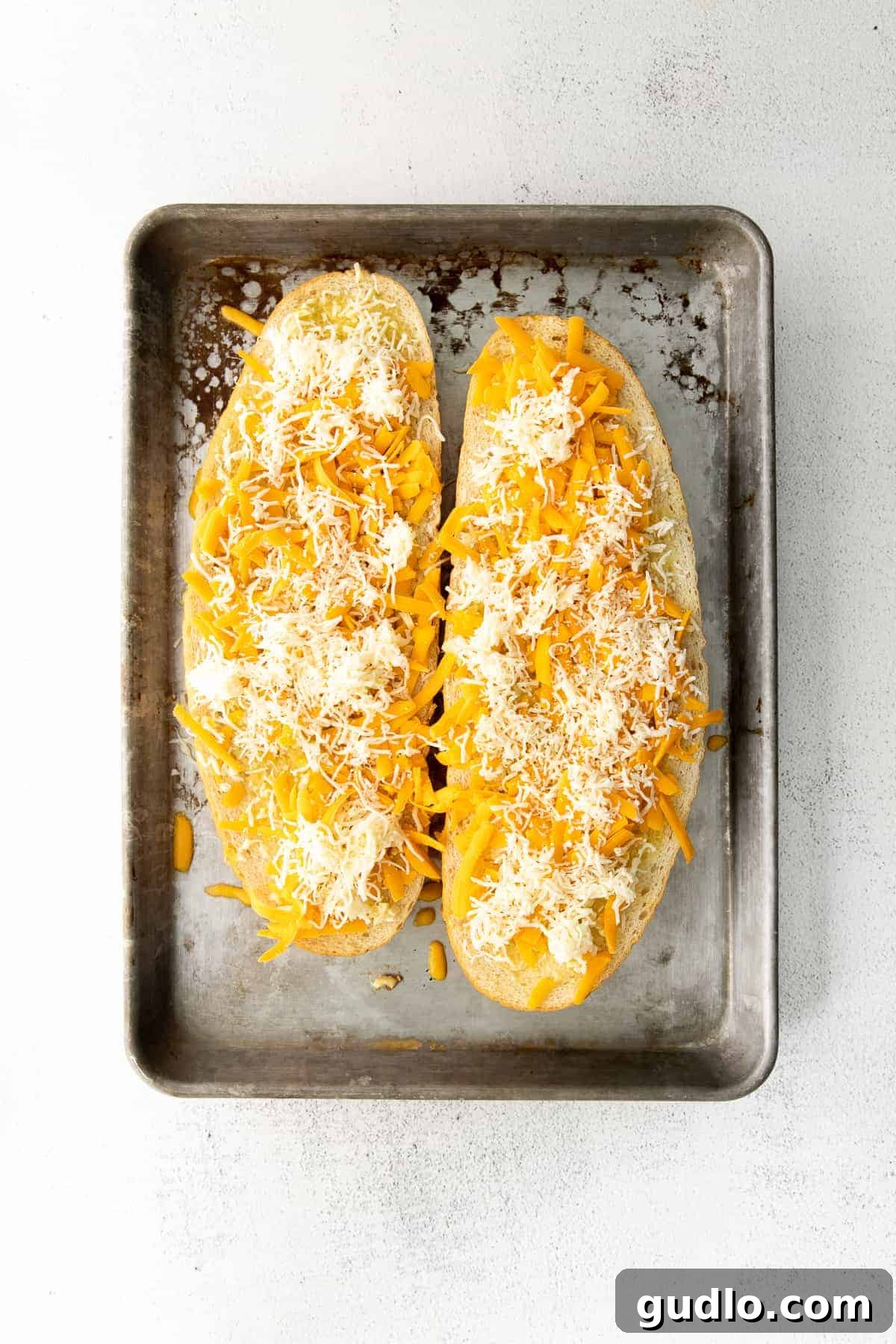 Golden Cheesy Garlic Bliss 6 Garlic bread topped with shredded cheddar and mozzarella cheese before being baked.