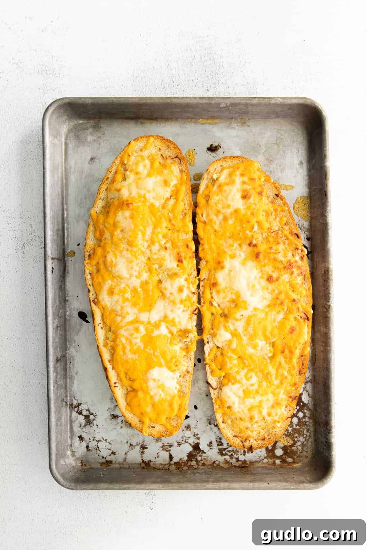 Golden Cheesy Garlic Bliss 8 Freshly baked cheesy garlic bread on a baking sheet, golden and bubbly.