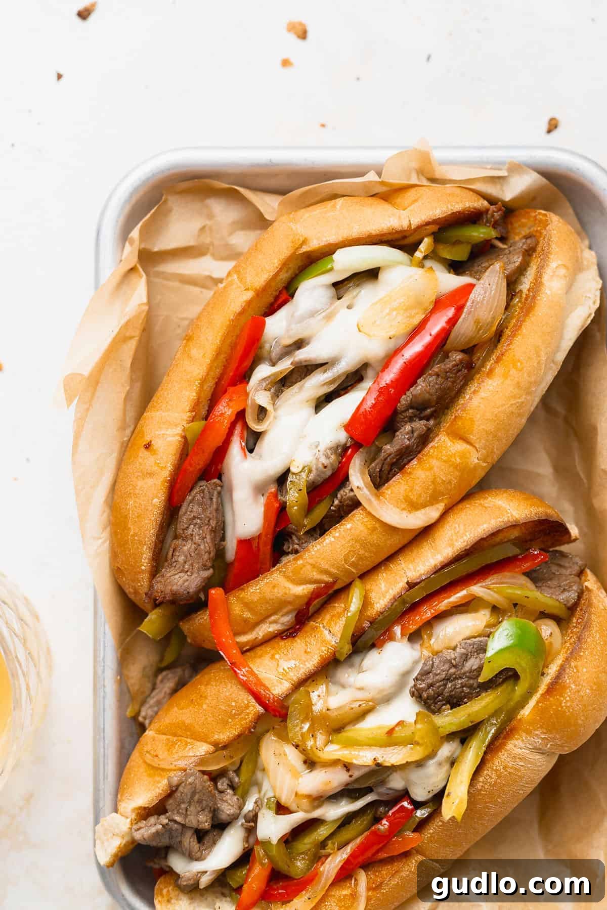 Philadelphia's Signature Sandwich 2 Two perfectly assembled Philly cheesesteak sandwiches on a rustic plate, ready to be enjoyed.