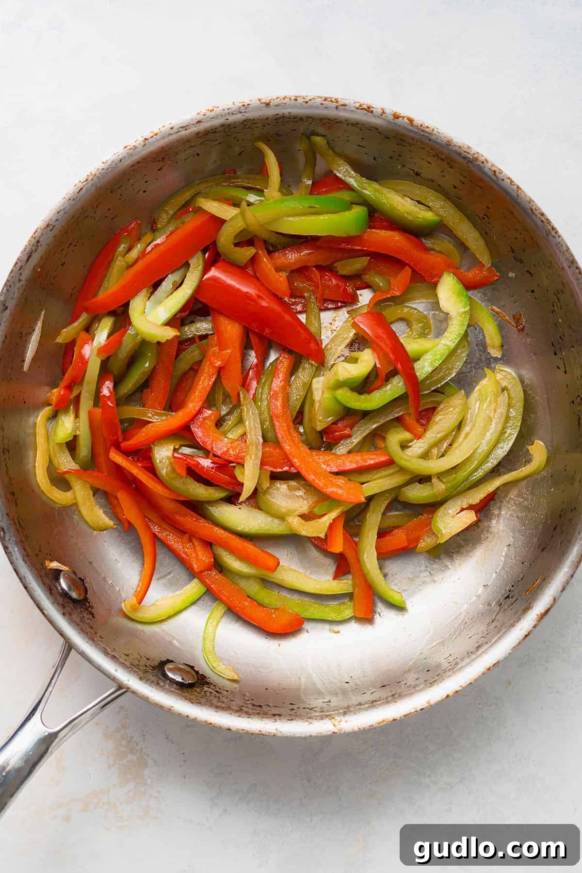 Philadelphia's Signature Sandwich 3 Thinly sliced bell peppers and onions sizzling in a hot sauté pan, ready to be caramelized.