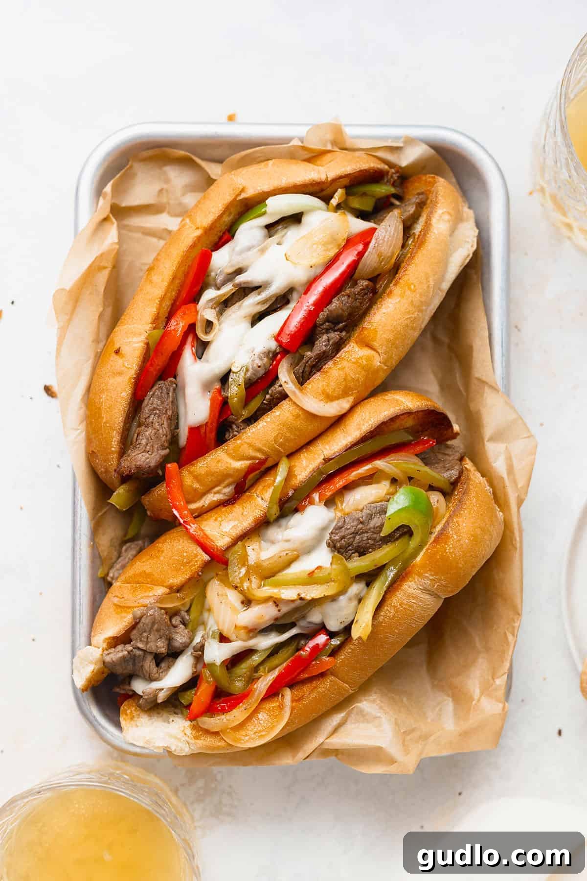 Philadelphia's Signature Sandwich 5 A platter laden with several perfectly crafted Philly cheese steaks, garnished and ready for serving.