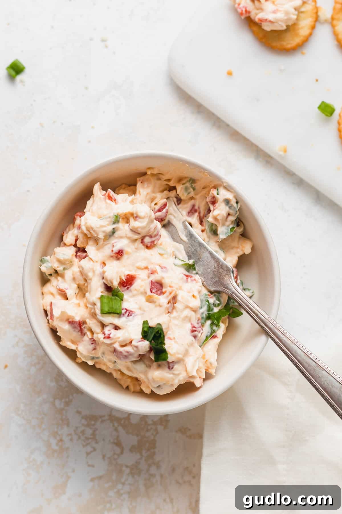 Make your own homemade pimento cheese for a decadent spread or easy dip for crackers. Enjoy! pimento cheese with knife in bowl
