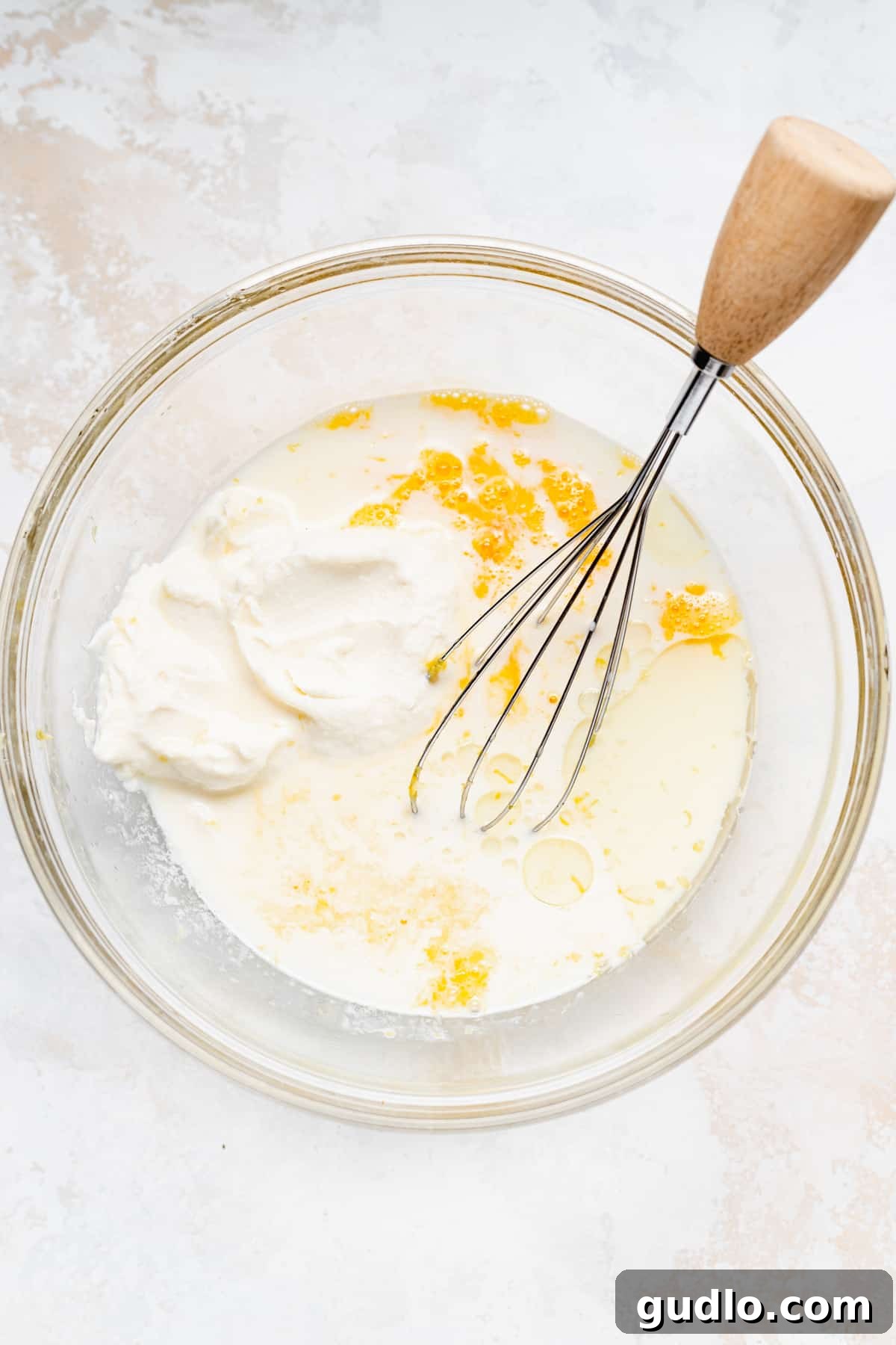 Smooth pancake batter with blueberries in a mixing bowl