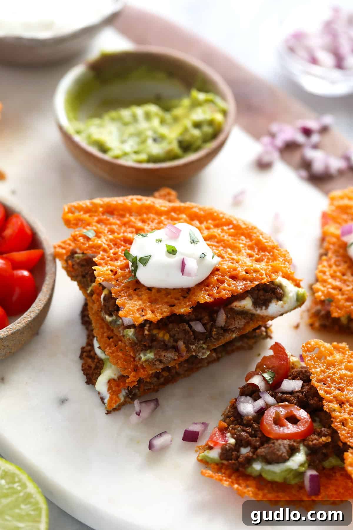 A vibrant keto quesadilla, generously topped with creamy Greek yogurt, finely diced red onion, and fresh cilantro, showcasing its rich fillings and crispy cheese base.
