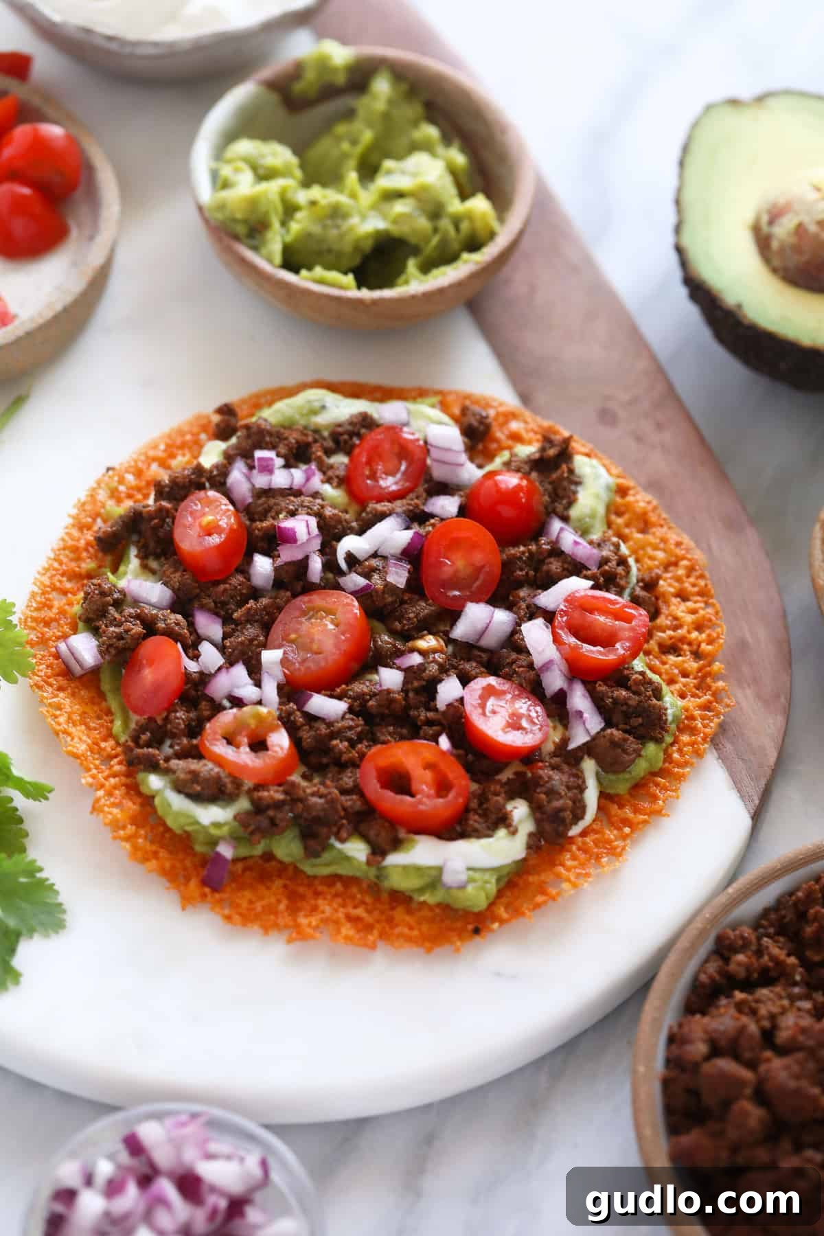 A perfectly assembled keto quesadilla, quartered and garnished with vibrant red onions and juicy cherry tomatoes, ready to be enjoyed.