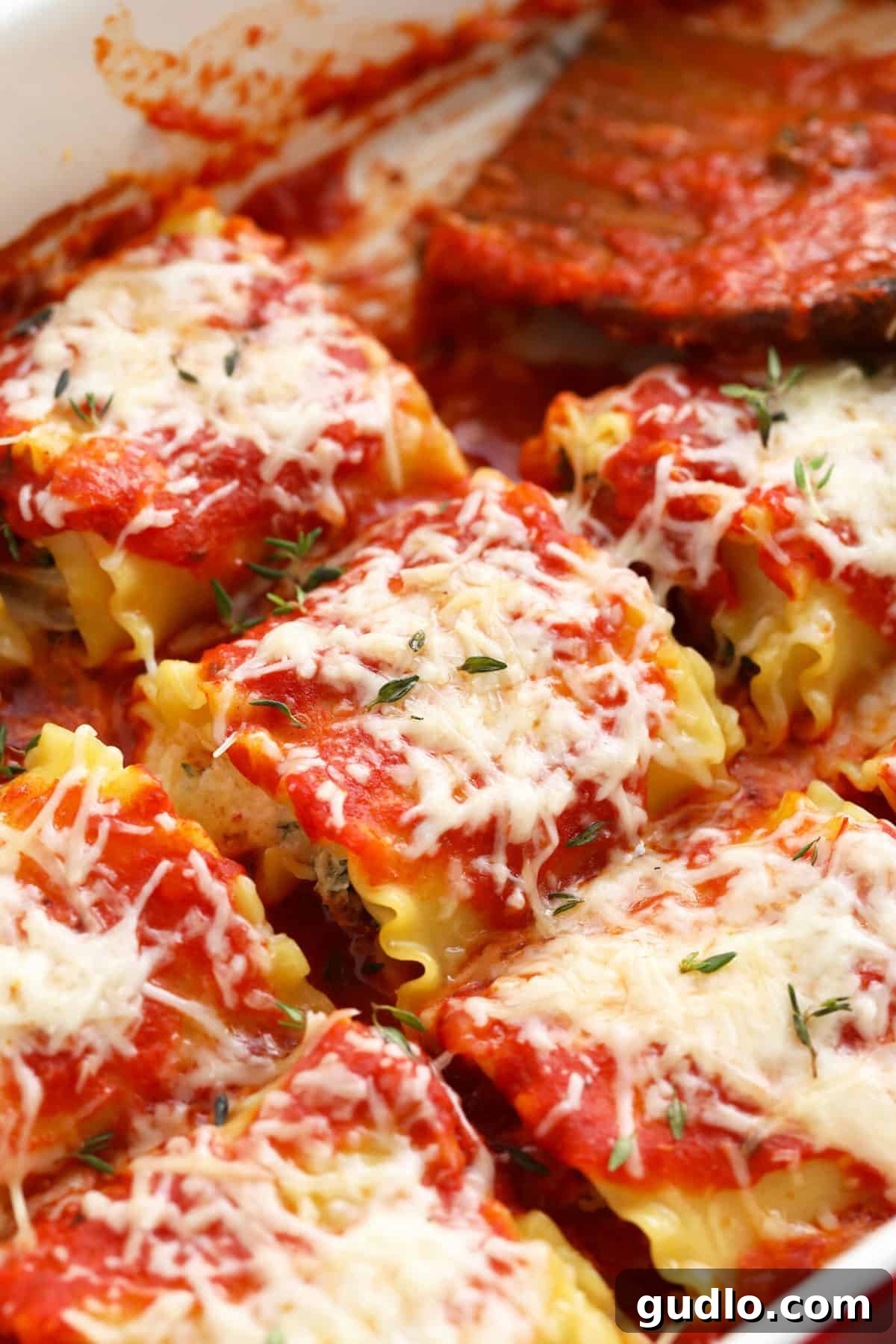 Wholesome Kale Lasagna Roll Ups 2 Beautifully baked Kale Lasagna Roll Ups in a casserole dish, ready to serve.