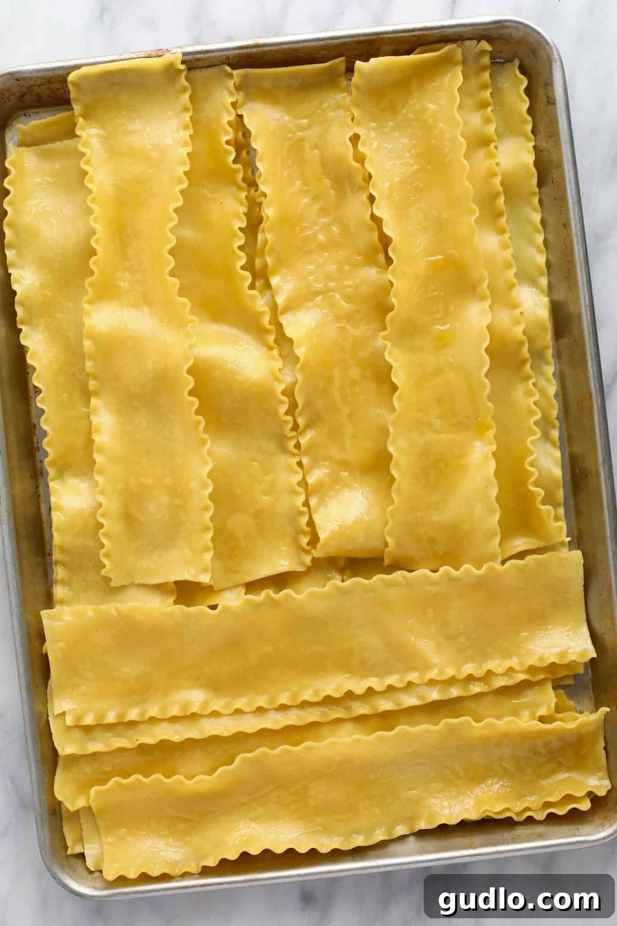 Wholesome Kale Lasagna Roll Ups 3 Partially cooked lasagna noodles laid out flat on a baking sheet, ready for filling.
