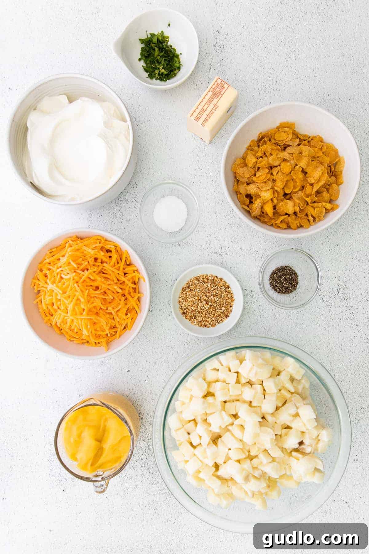 Key Ingredients for Cheesy Hashbrown Casserole Assortment of fresh ingredients laid out on a kitchen counter for the cheesy hashbrown potato casserole.