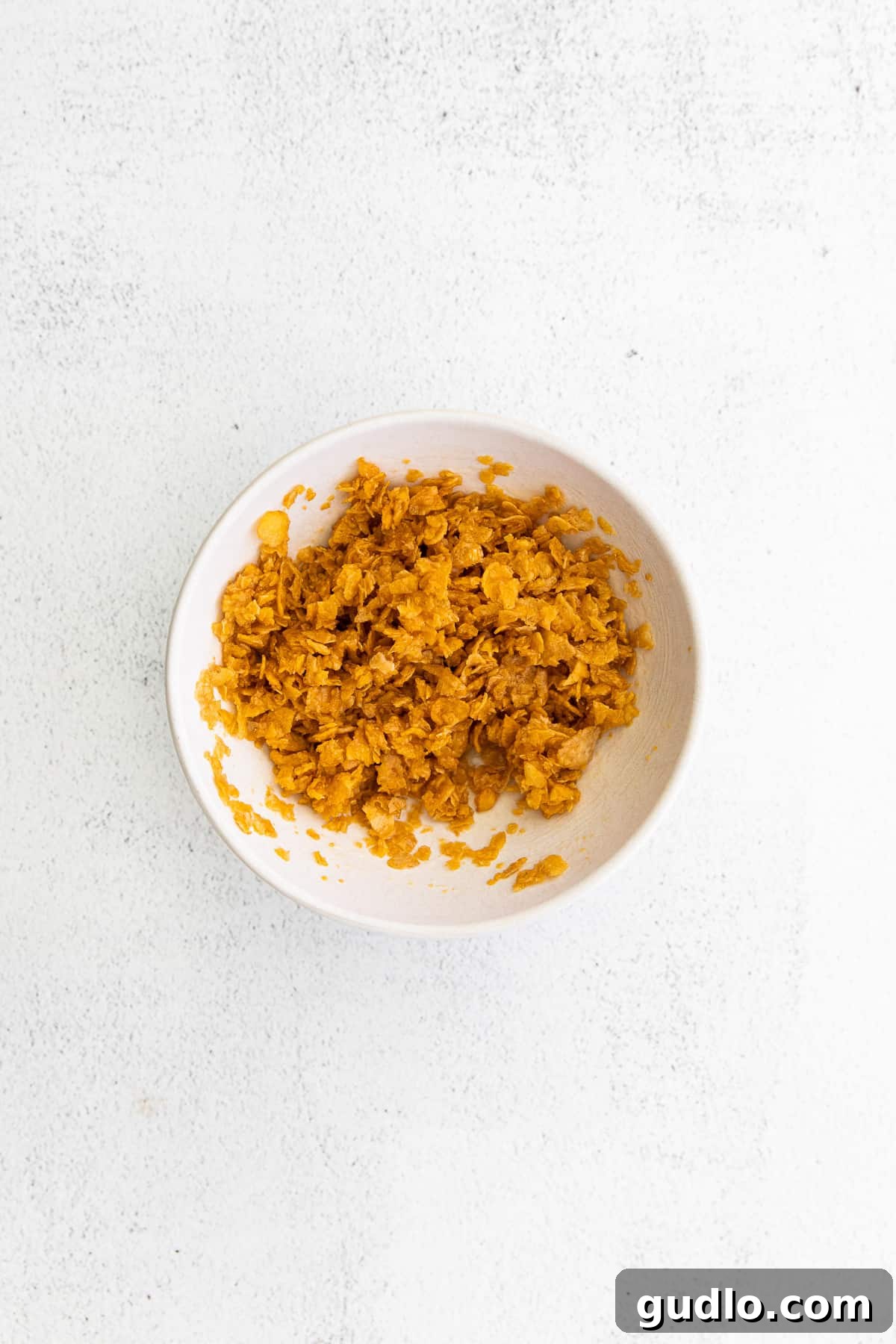 Corn Flakes Topping Preparation Crushed cornflakes and melted butter in a bowl, ready for the topping.