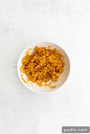 Crispy Golden Cheese Potatoes 3 A bowl of shredded carrots on a white surface, representing the hashbrown mixture.